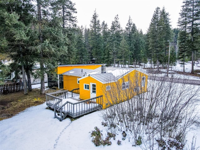1613 Main Ave, Libby, MT 59923 - snow covered house with a deck and a wooded view