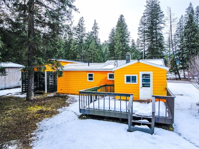 1613 Main Ave, Libby, MT 59923 - snow covered rear of property with a chimney, a deck, and metal roof