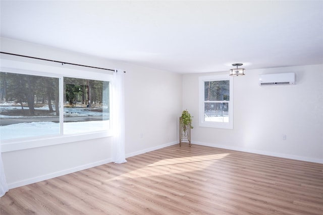 1613 Main Ave, Libby, MT 59923 - unfurnished room featuring a wall unit AC, light wood-type flooring, and baseboards