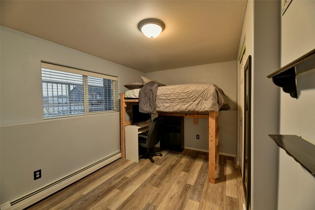 873 Guthrie Rd, Helena, MT 59602 - bedroom with light wood finished floors, a baseboard heating unit, and baseboards