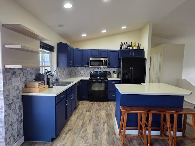 873 Guthrie Rd, Helena, MT 59602 - kitchen featuring black appliances, a kitchen bar, blue cabinets, and lofted ceiling
