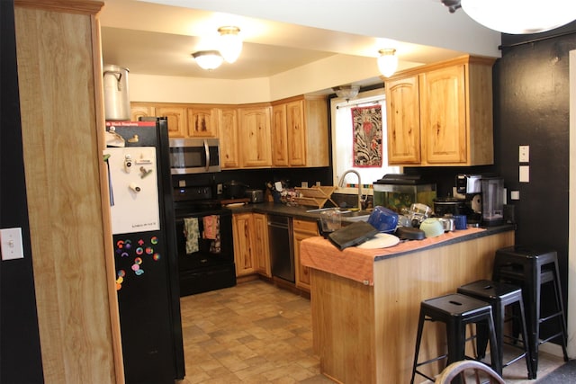 1626 W Central Ave, Missoula, MT 59801 - kitchen with appliances with stainless steel finishes, a peninsula, a kitchen breakfast bar, light brown cabinetry, and stone finish flooring