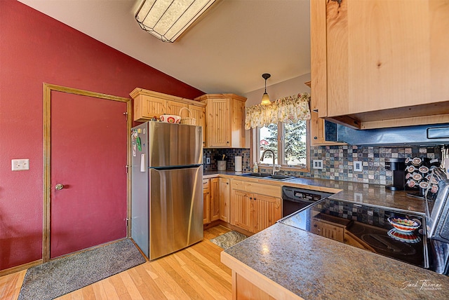 kitchen with black appliances, a sink, vaulted ceiling, light wood finished floors, and decorative backsplash