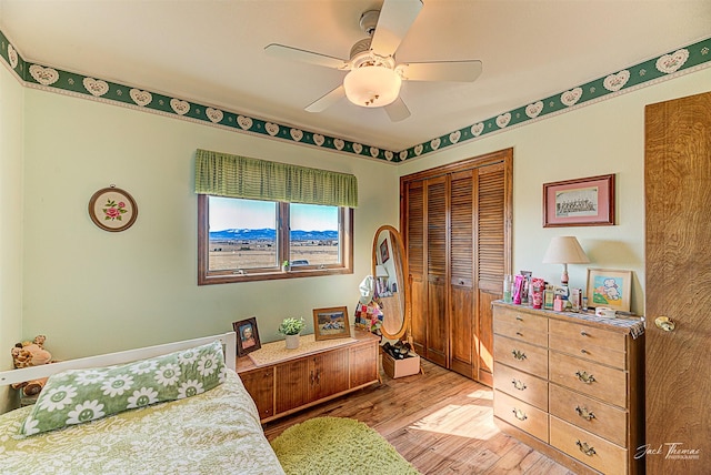 bedroom featuring a closet, light wood-style flooring, and ceiling fan