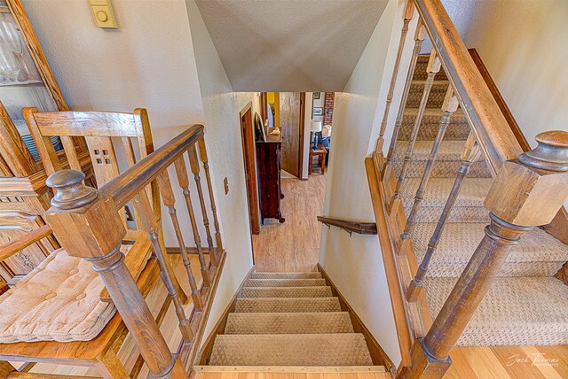 stairway featuring wood finished floors and baseboards