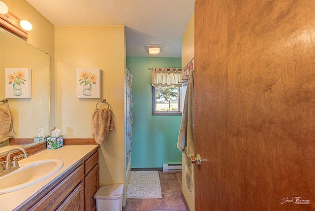 bathroom featuring a baseboard heating unit, vanity, and baseboards