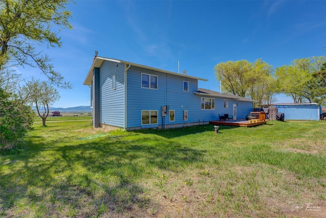 back of house featuring a wooden deck and a yard
