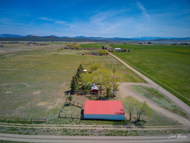 view of rural area featuring a mountain backdrop and agricultural land