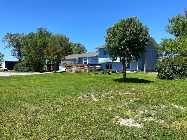 view of grassy yard featuring a deck