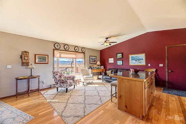 living area with a ceiling fan, light wood-type flooring, vaulted ceiling, and a baseboard radiator