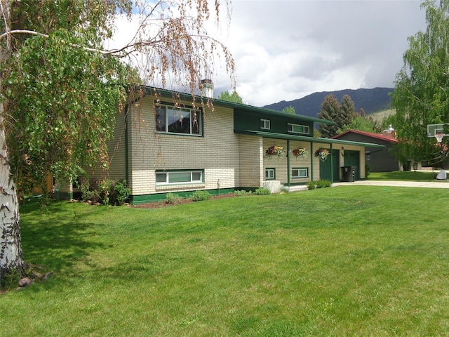 117 Rocky Mountain Ln, Butte, MT 59701 - view of front facade featuring an attached garage, driveway, a mountain view, and a front lawn