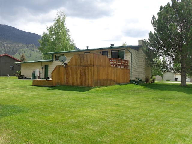 117 Rocky Mountain Ln, Butte, MT 59701 - rear view of house featuring a lawn, a chimney, and a deck with mountain view