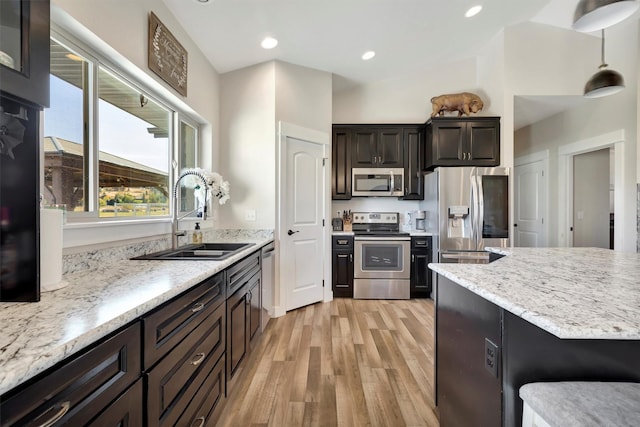 3682 Dietz Dr, Stevensville, MT 59870 - kitchen featuring light wood-type flooring, open floor plan, a center island, arched walkways, and appliances with stainless steel finishes