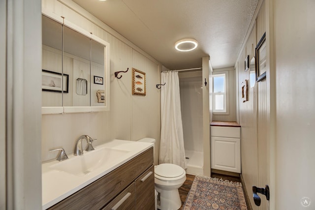 2931 Melrose Rd, Helena, MT 59602 - bathroom with toilet, vanity, a stall shower, wood finished floors, and a textured ceiling