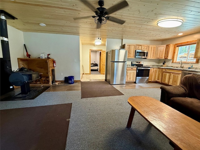 421 Cherry Creek Rd, Thompson Falls, MT 59873 - living room with a wood stove, wooden ceiling, baseboards, light colored carpet, and ceiling fan