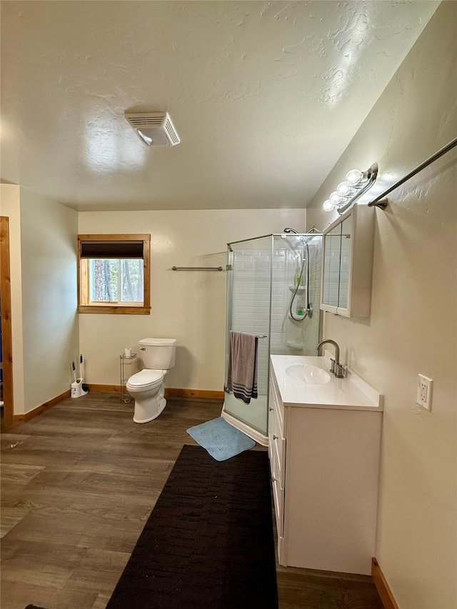 421 Cherry Creek Rd, Thompson Falls, MT 59873 - bathroom with vanity, wood finished floors, toilet, a shower stall, and a textured ceiling