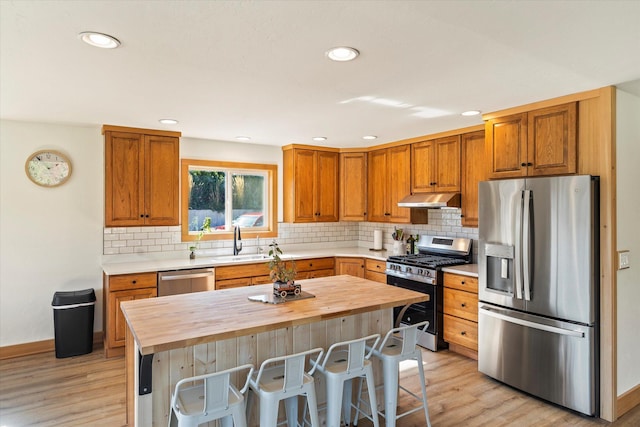 140 Swan River Rd, Bigfork, MT 59911 - kitchen featuring appliances with stainless steel finishes, butcher block counters, under cabinet range hood, light wood finished floors, and recessed lighting