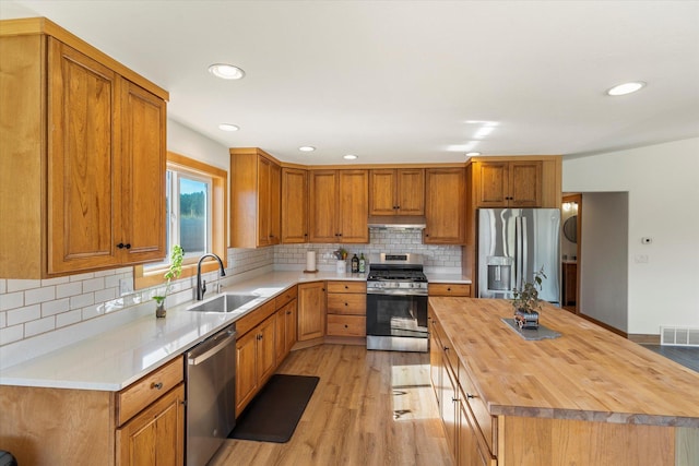 140 Swan River Rd, Bigfork, MT 59911 - kitchen featuring stainless steel appliances, wood counters, light wood-type flooring, decorative backsplash, and recessed lighting