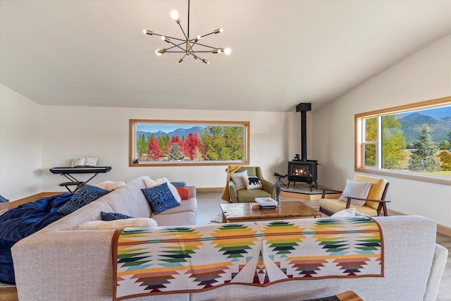 140 Swan River Rd, Bigfork, MT 59911 - living room featuring vaulted ceiling, a wood stove, a chandelier, and wood finished floors