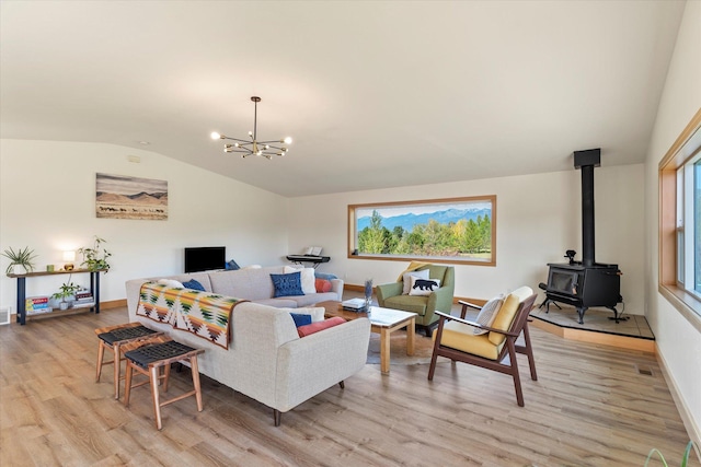 140 Swan River Rd, Bigfork, MT 59911 - living area featuring lofted ceiling, a wood stove, light wood-style floors, and a chandelier