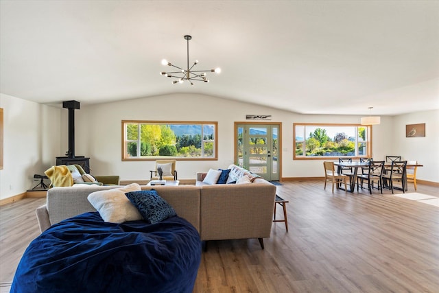 140 Swan River Rd, Bigfork, MT 59911 - living room with a wood stove, lofted ceiling, wood finished floors, and a chandelier