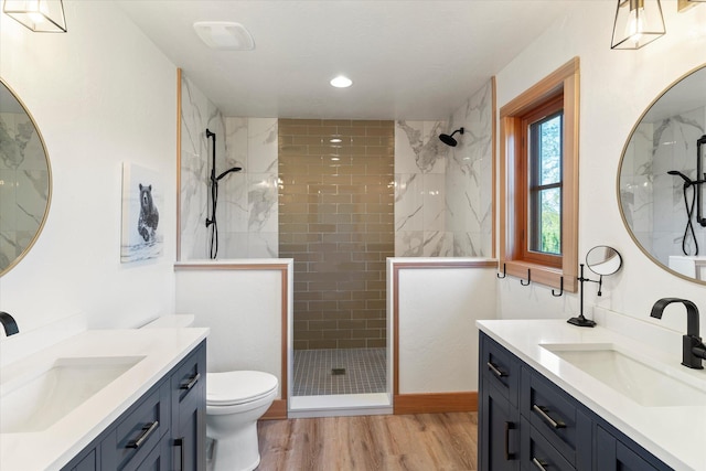 140 Swan River Rd, Bigfork, MT 59911 - full bathroom featuring two vanities, tiled shower, wood finished floors, and recessed lighting