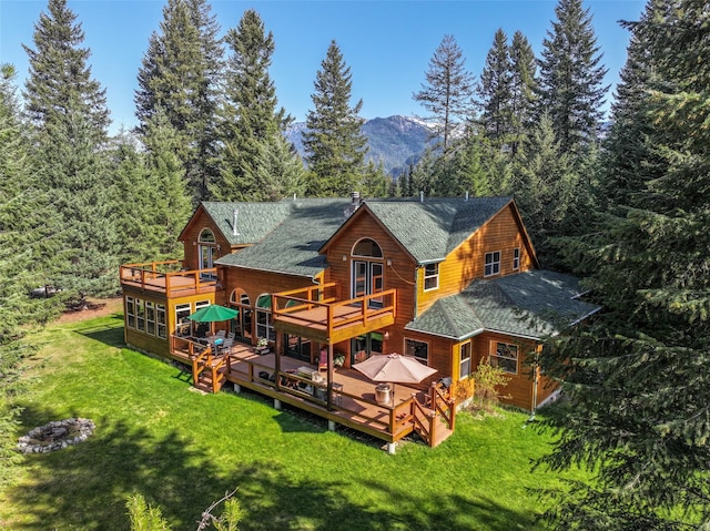 133 Klakken Rd, Noxon, MT 59853 - rear view of property with a yard, a deck with mountain view, and roof with shingles