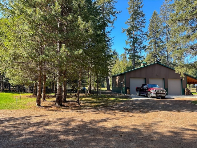 133 Klakken Rd, Noxon, MT 59853 - view of side of home featuring a chimney, an outdoor structure, driveway, and a detached garage