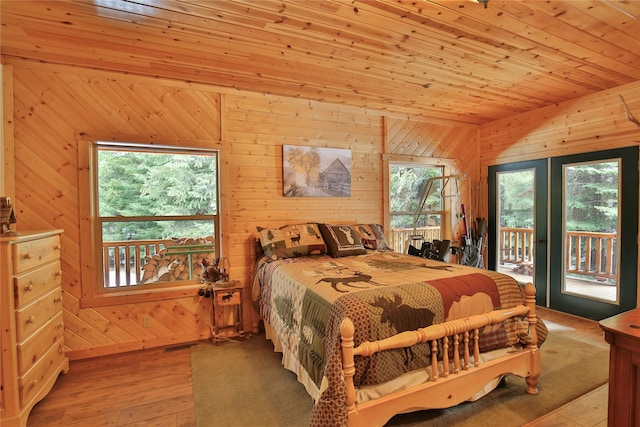 133 Klakken Rd, Noxon, MT 59853 - bedroom featuring multiple windows, wood walls, hardwood / wood-style flooring, and access to outside
