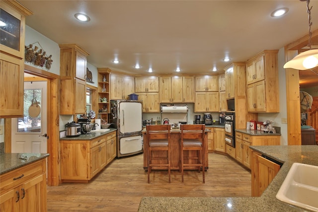 133 Klakken Rd, Noxon, MT 59853 - kitchen featuring a sink, freestanding refrigerator, black oven, a warming drawer, and light wood-style flooring