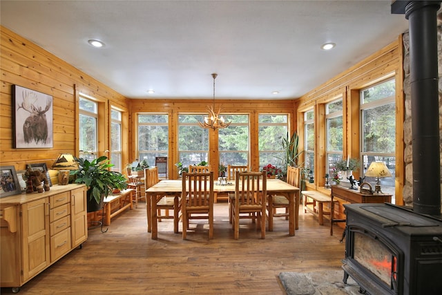133 Klakken Rd, Noxon, MT 59853 - dining space featuring a notable chandelier, a wood stove, wood finished floors, and plenty of natural light
