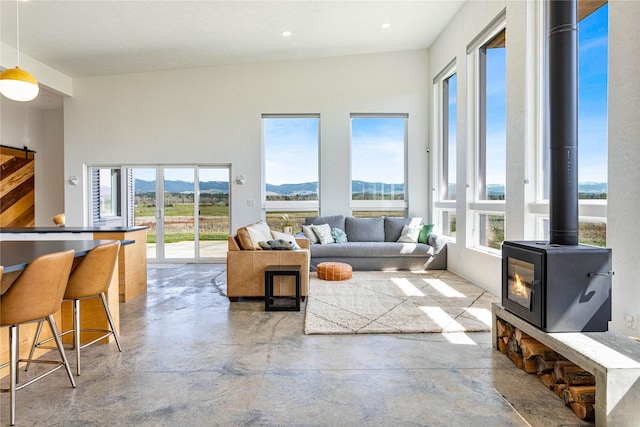 5052 Hoblitt Ln N, Florence, MT 59833 - living room featuring a wood stove, concrete flooring, a mountain view, and recessed lighting