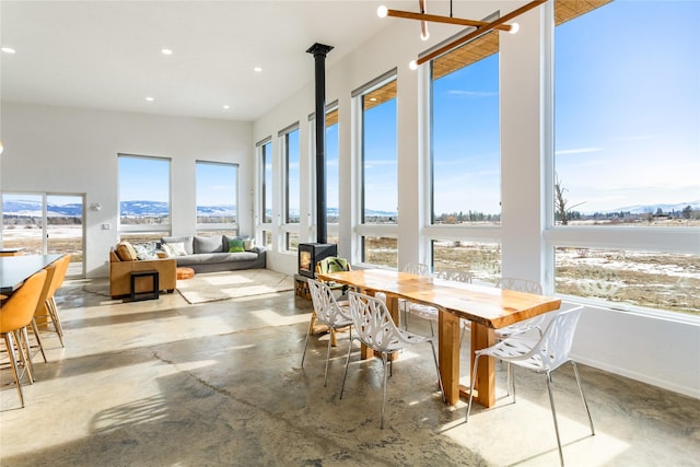 5052 Hoblitt Ln N, Florence, MT 59833 - sunroom featuring finished concrete floors, plenty of natural light, a wood stove, recessed lighting, and a mountain view