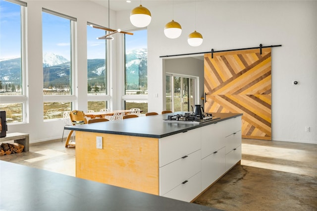 5052 Hoblitt Ln N, Florence, MT 59833 - kitchen featuring stainless steel gas cooktop, white cabinetry, modern cabinets, dark countertops, and finished concrete floors