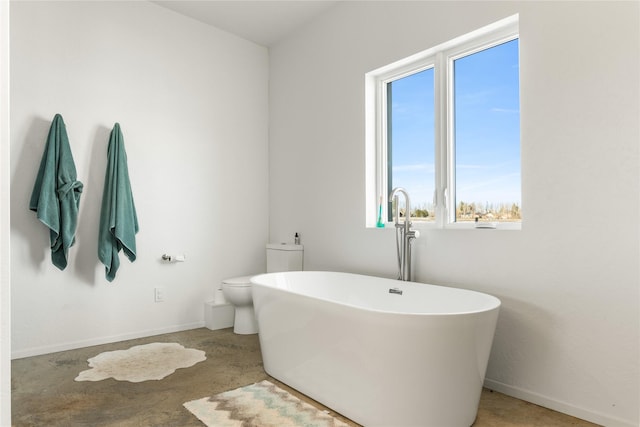 5052 Hoblitt Ln N, Florence, MT 59833 - full bathroom featuring healthy amount of natural light, a freestanding bath, toilet, and baseboards