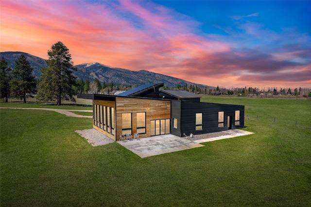 5052 Hoblitt Ln N, Florence, MT 59833 - back of house with a mountain view, a lawn, and a patio
