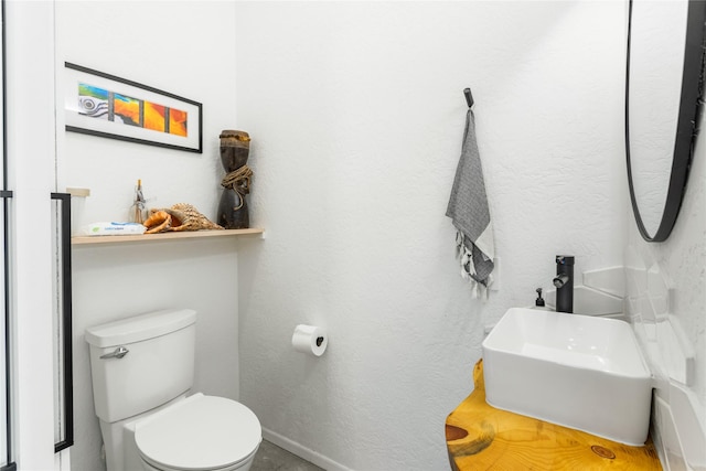 5052 Hoblitt Ln N, Florence, MT 59833 - bathroom featuring toilet, baseboards, and a textured wall