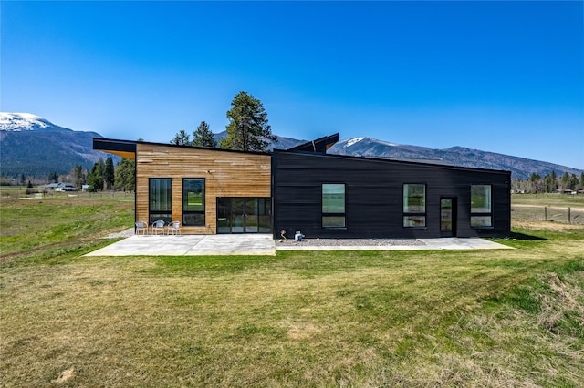 5052 Hoblitt Ln N, Florence, MT 59833 - back of property featuring a patio, a mountain view, and a lawn