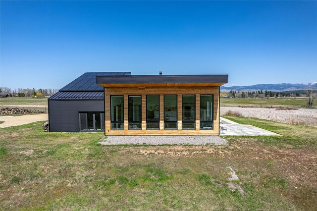 5052 Hoblitt Ln N, Florence, MT 59833 - rear view of house with a standing seam roof, a mountain view, and metal roof