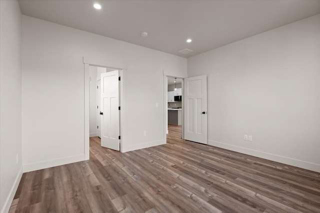 1048 Mill Creek Dr, Bigfork, MT 59911 - unfurnished bedroom with wood finished floors, baseboards, and recessed lighting