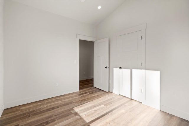 1048 Mill Creek Dr, Bigfork, MT 59911 - unfurnished bedroom with wood finished floors, baseboards, recessed lighting, and high vaulted ceiling