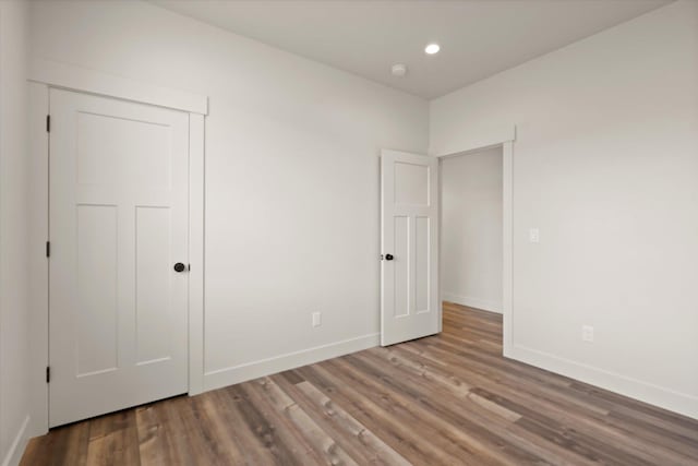 1048 Mill Creek Dr, Bigfork, MT 59911 - unfurnished bedroom with baseboards, wood finished floors, recessed lighting, and a closet