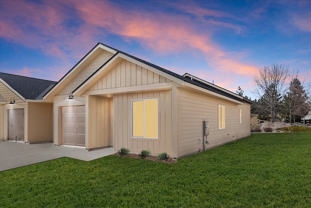 1048 Mill Creek Dr, Bigfork, MT 59911 - property exterior at dusk featuring a yard, board and batten siding, concrete driveway, and a shingled roof