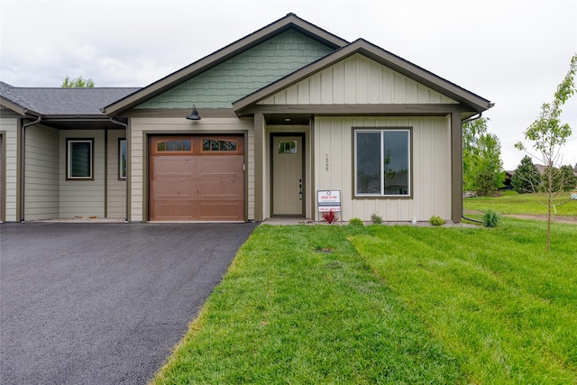1048 Mill Creek Dr, Bigfork, MT 59911 - view of front of property featuring a garage, driveway, a front yard, and board and batten siding
