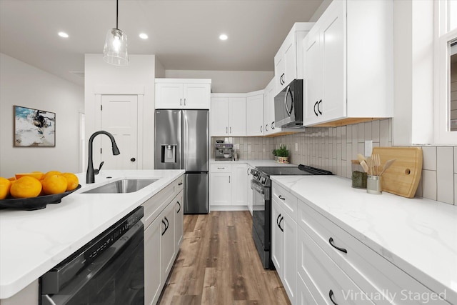 1048 Mill Creek Dr, Bigfork, MT 59911 - kitchen with black appliances, a sink, light wood-style flooring, white cabinets, and recessed lighting