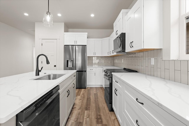 1048 Mill Creek Dr, Bigfork, MT 59911 - kitchen with black appliances, a sink, light wood-style flooring, white cabinetry, and decorative backsplash