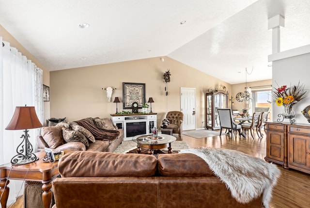 living area featuring wood finished floors, a fireplace, and vaulted ceiling