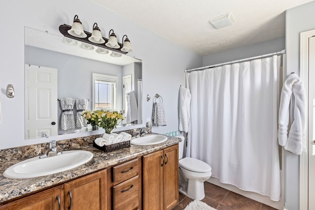 full bath featuring tile patterned floors, toilet, double vanity, and a sink