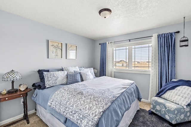 bedroom featuring baseboards, carpet floors, and a textured ceiling