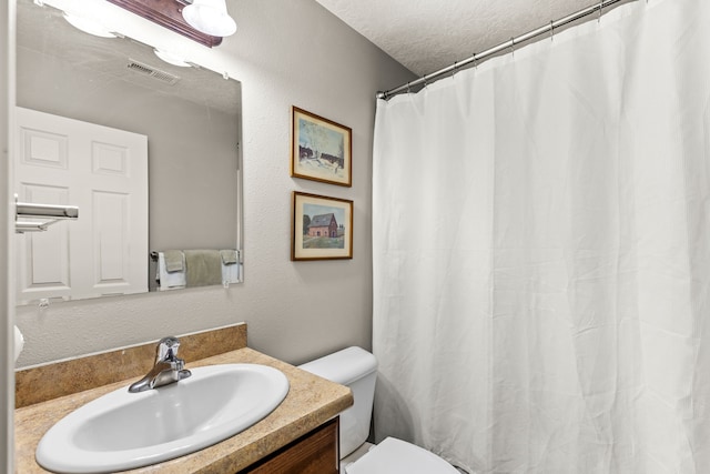 bathroom with vanity, a shower with curtain, visible vents, a textured ceiling, and toilet